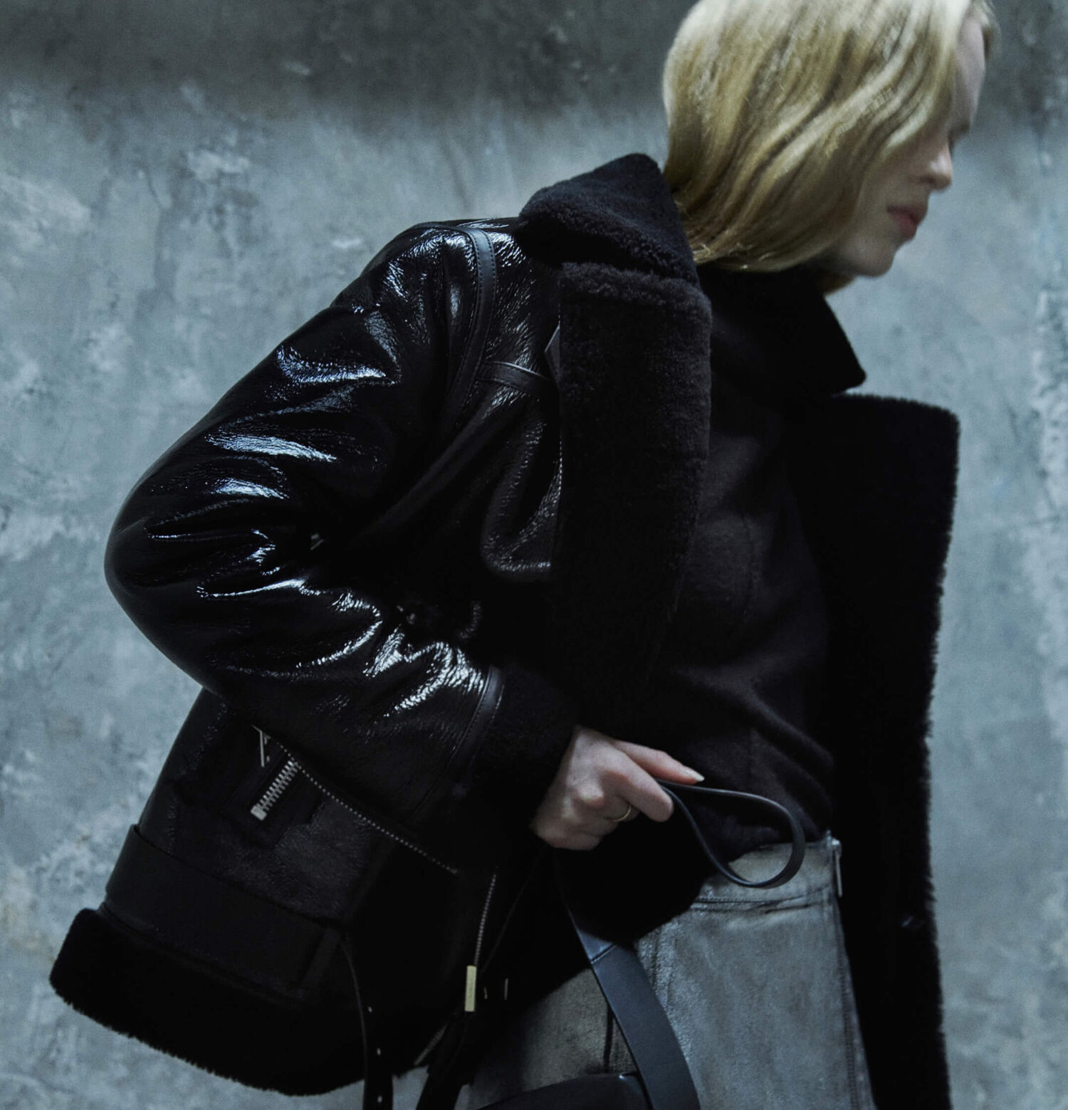 Woman wearing a leather shearling jacket and grey metallic skirt