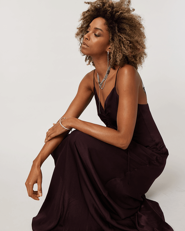 Woman Crouched Down Wearing Long Black Slip Dress