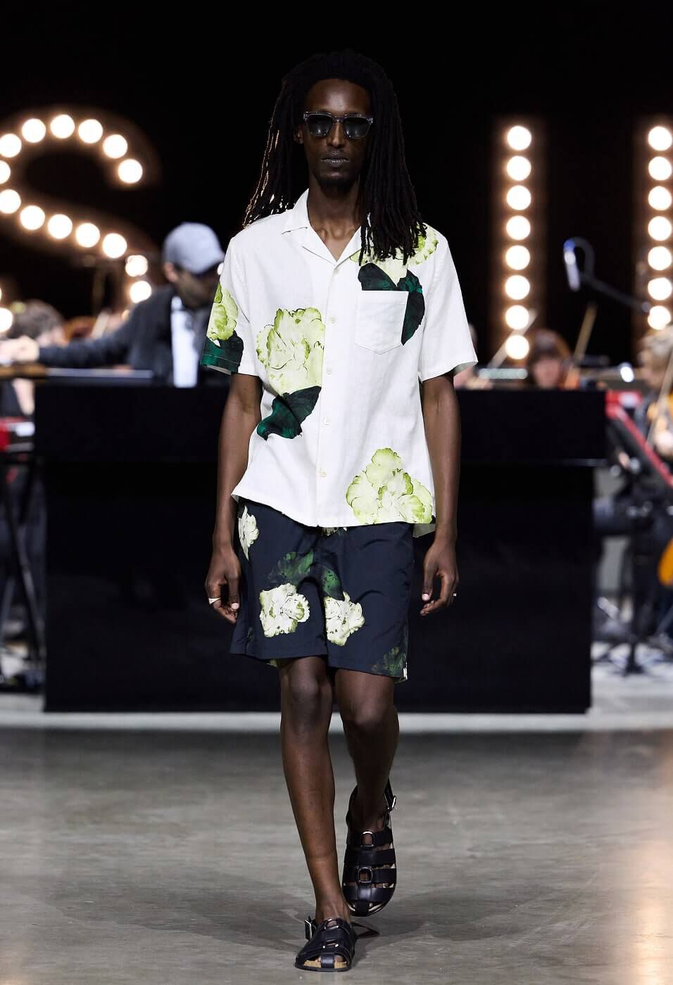 Man wearing white floral shirt with matching black floral shorts 
