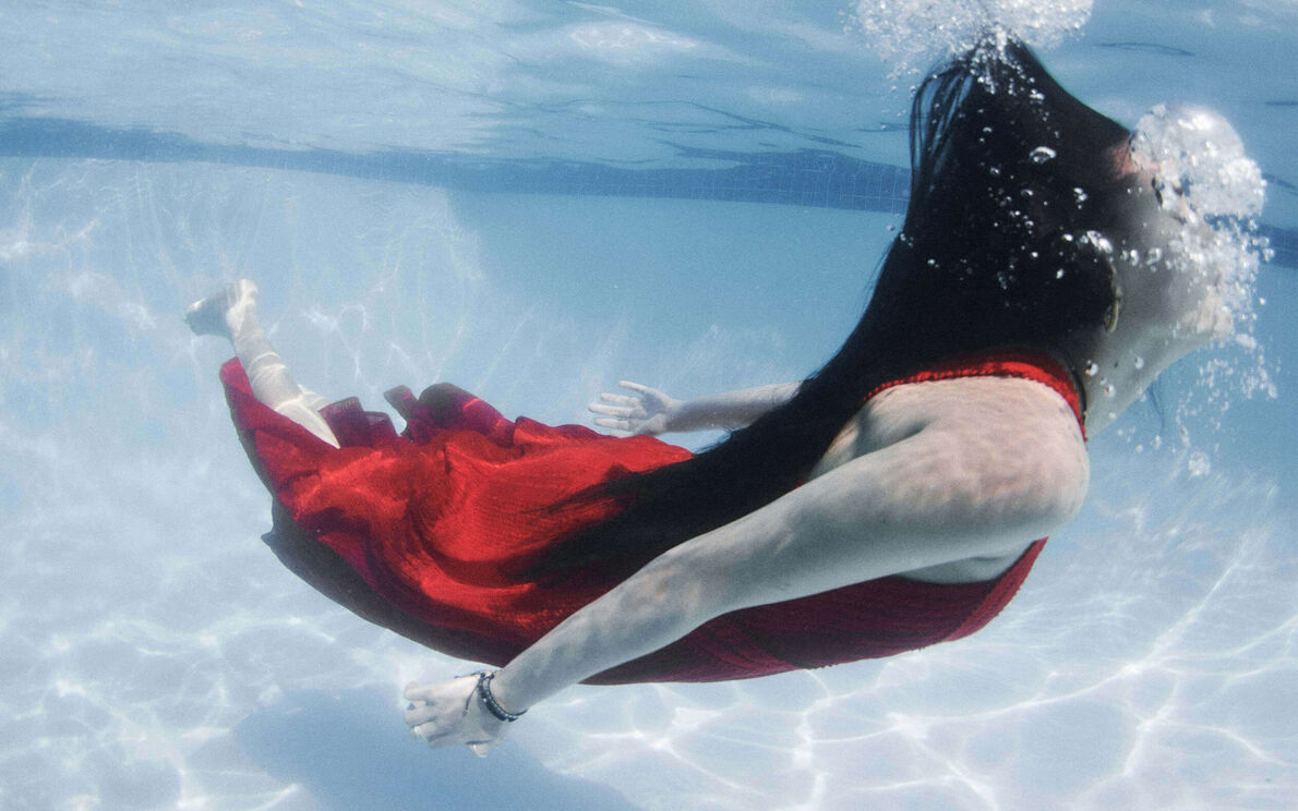 Dame im Swimbad in einem roten Kleid