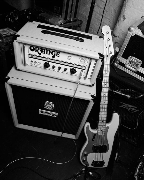 Black and white photograph of speakers and an electric guitar.