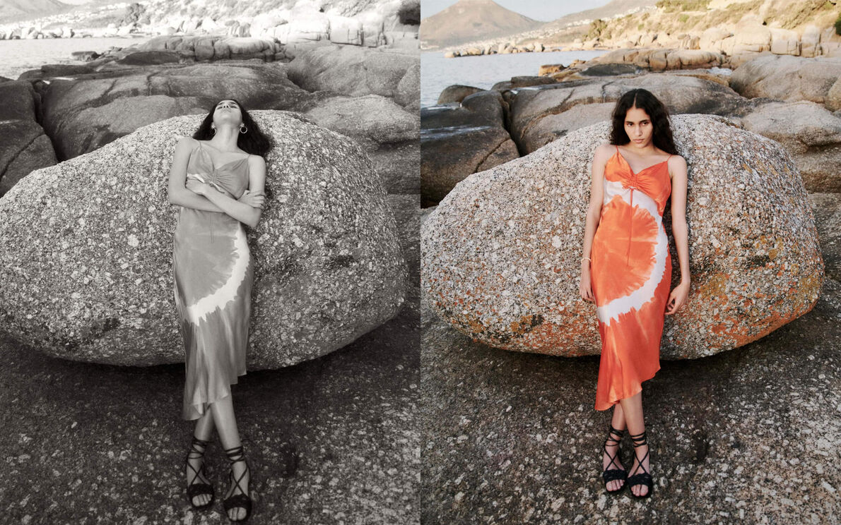 Dame trägt ein orange-weißes Batikkleid, Sie lehnt sich an einem Strand an einen Felsbrocken