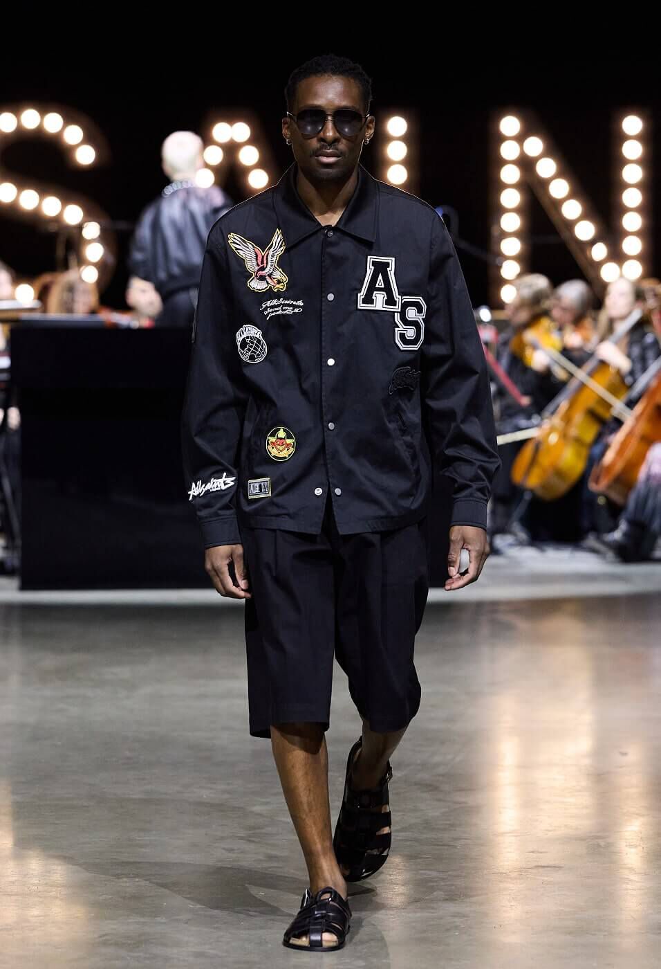 Man wearing black leatherman jacket with black shorts