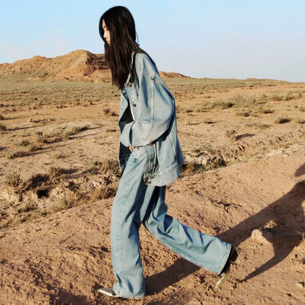 Woman wearing oversized jeans and denim jacket in the desert