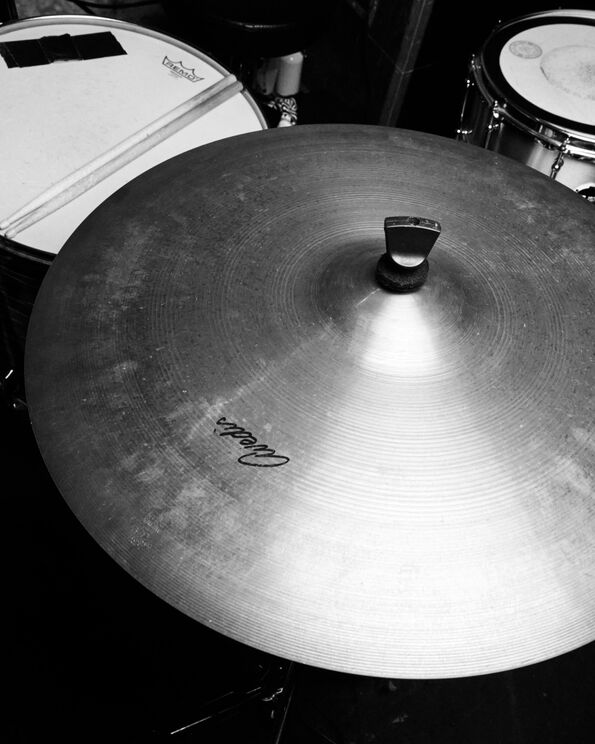 Black and white photograph closeup of a ride cymbal.